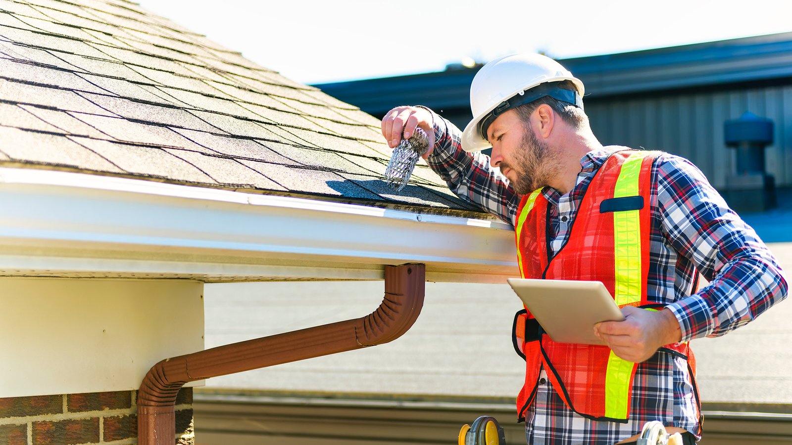Roofing crew applying underlayment and flashing during residential install