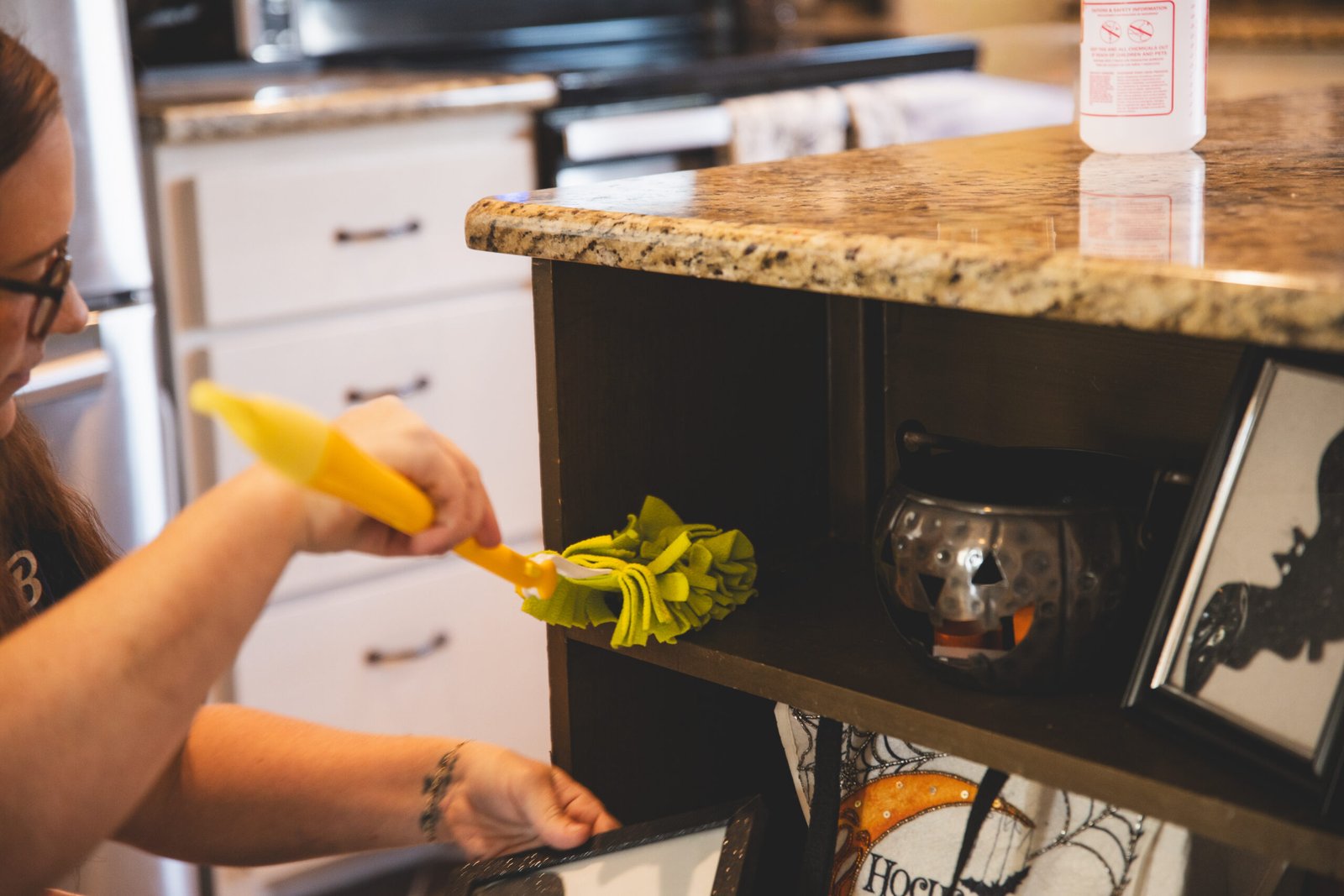 A cleaning professional using a duster in Benbrook, offering cleaning services by The Mop & Broom