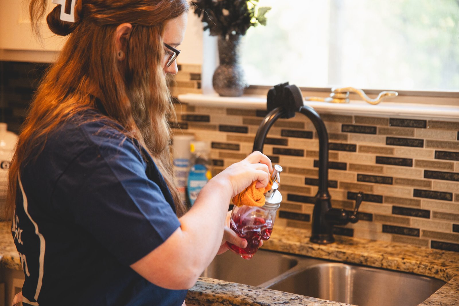 A cleaning professional from The Mop & Broom performing kitchen cleaning near me